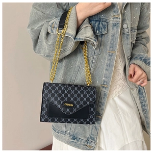 Détail du petit sac vintage avec motif monogramme classique et chaîne en métal doré