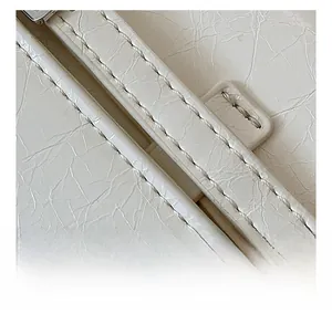 Macro view of detailed stitching on high-quality white textured leather fashion bag