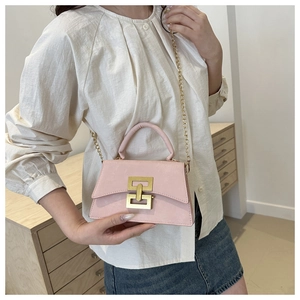 Sac bandoulière rose avec boucle chaîne dorée et bandoulière métallique sur modèle