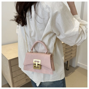 Vue détaillée du sac rose avec bandoulière chaîne dorée et boucle géométrique