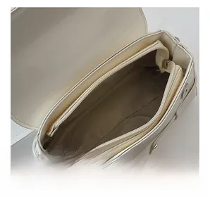 Detail view of the multi-compartment interior and herringbone lining of this cream handbag