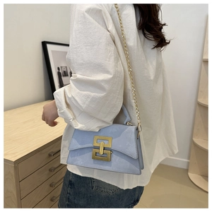 Vue portée d'un sac bandoulière bleu clair avec chaîne dorée et boucle de verrouillage
