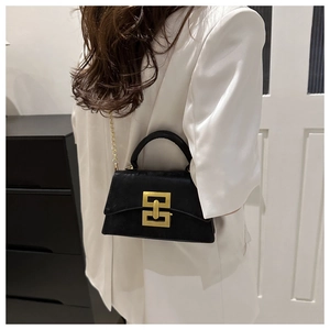 Détail du sac bandoulière noir en cuir avec chaîne dorée et boucle géométrique métallique