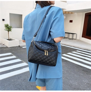 Chic quilted black leather crossbody bag featured in an outdoor city street style