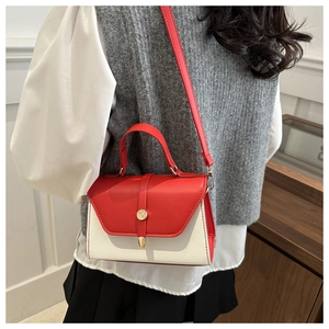 Detailed side view of a red and cream PU leather crossbody bag with metal buckle