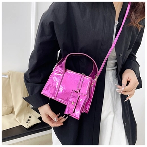 Détail d'un sac à main rose métallique avec petit porte-monnaie porté par un modèle