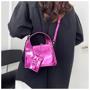Détail d'un sac à bandoulière rose métallisé et mini pochette sur un mannequin mode