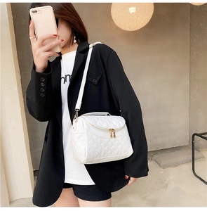 Detailed view of a white quilted PU leather handbag with gold zipper and thin strap