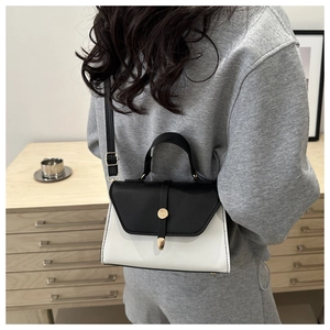 Minimalist black and white contrast mini crossbody bag worn by a model in a natural setting