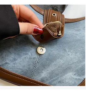 Détail du tissu denim bleu et cuir marron avec fermeture à boucle magnétique argentée