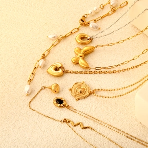 Détails de colliers dorés avec pendentifs papillon, médaillon et perles baroques
