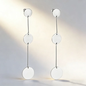 Macro view of polished silver geometric round drop earrings in stainless steel
