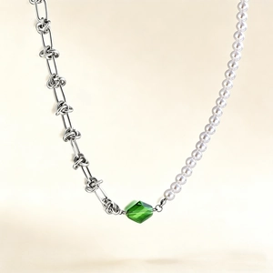 Collier asymétrique avec cristal vert, nœuds en métal et demi-chaîne en perles blanches