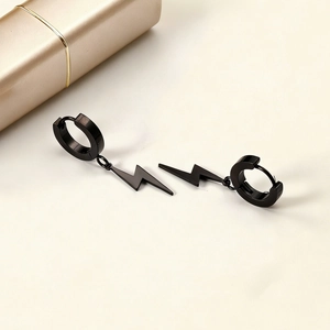Boucles d'oreilles minimalistes en acier noir avec pendentifs éclair sur fond beige