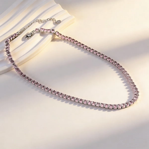 Detail of silver tennis necklace with pink crystals, lobster clasp, and extender chain