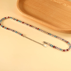 Macro shot of colorful oval-cut stones on a stainless steel tennis necklace with lobster clasp