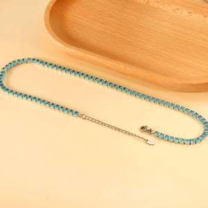Detail of blue square-cut gemstones on a polished stainless steel tennis necklace
