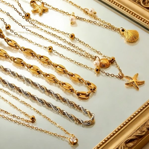 Disposizione dettagliata di collane dorate con conchiglie e stelle marine su specchio vintage
