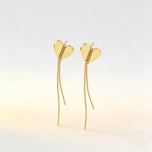 Boucles d'oreilles cœur en acier doré avec de délicates chaînes à franges pendantes