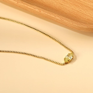 Dettaglio macro del ciondolo in zircone giallo taglio marquise su catena box in oro 18K