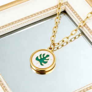 Détail du collier plaqué or 18K avec pendentif feuille de monstera sur nacre blanche