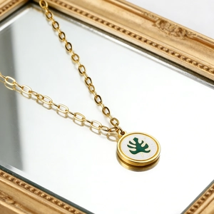 Collier plaqué or 18 carats avec pendentif rond en nacre et motif feuille de monstera