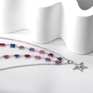 Layered stainless steel star pendant necklace with colorful glitter accents on white stone