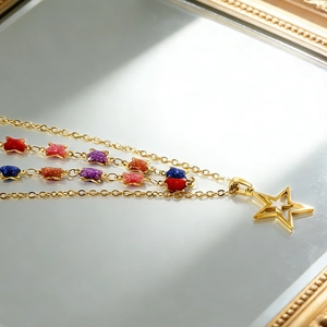 Detail showing multi-layer 18K gold-plated star charms necklace with colorful glitter finish