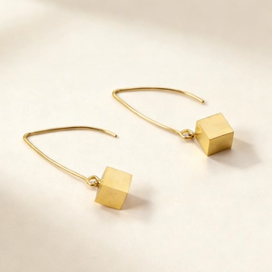Minimalist gold cube drop earrings with sleek wire hooks and brushed metal finish texture