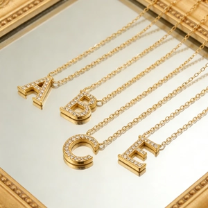 Macro detail of 18K gold plated necklaces with A B C E crystal initial pendants