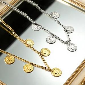 Gold and silver coin portrait necklaces with thick link chain in mirror reflection