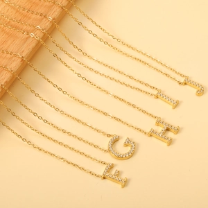 Detail view of 18K gold plated necklaces featuring zircon-encrusted letters F to J