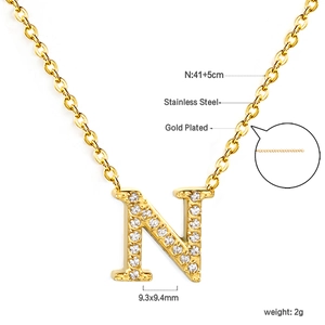 Detailed close-up of crystal paved letter N pendant on gold-plated stainless steel chain