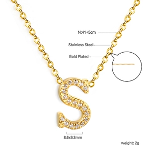 Macro detail of gold plated S letter pendant necklace with sparkling white zircons