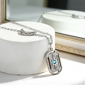 Detailed macro view of silver moon pendant with white crystals and blue gemstone pendant