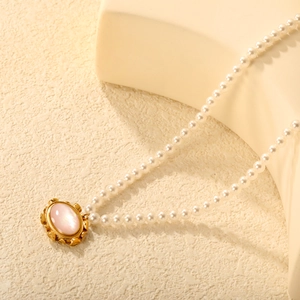 Elegant pearl necklace with vintage gold oval pendant and pink gemstone centerpiece