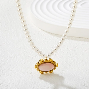 Elegant pearl necklace featuring a vintage oval pink shell pendant with gold engraving detail