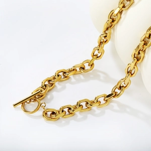 Close-up of golden stainless steel Cuban chain necklace featuring a classic OT toggle clasp