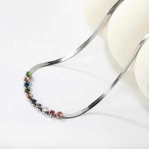 Detail of silver snake chain necklace featuring ten vibrant colorful gemstones in bezel settings