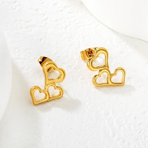 Boucles d'oreilles cœur creux triple plaquées or 18 carats sur surface en pierre blanche