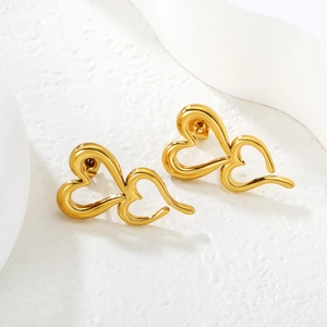 Vue macro de boucles d'oreilles clous double cœur évidé plaqué or 18k au fini brillant