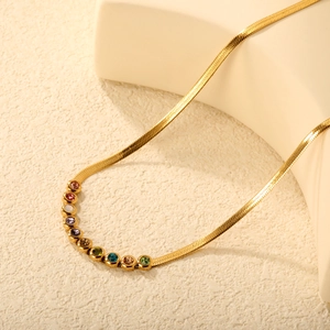 Elegant gold flat snake chain necklace with colorful round rhinestones on beige background