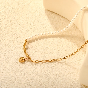 Elegant French style gold rose pendant necklace with white pearls on a minimalist background