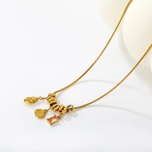 Golden shell pendant necklace with champagne gemstone and snake chain on a white background
