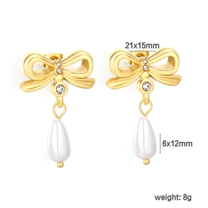 Détail de boucles d'oreilles nœud dorées 18K avec cristaux et perles en goutte