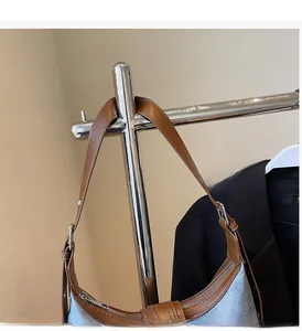 Détail de la poignée en cuir et du corps en toile bleue avec ferrures argentées du sac