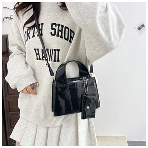Petit sac en cuir verni noir brillant avec un porte-monnaie assorti sur la bandoulière