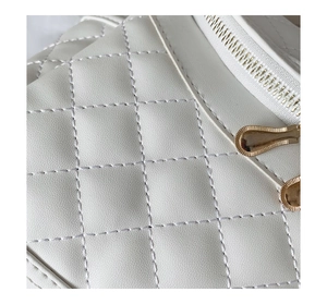 Detail of white quilted leather bag with dual golden teardrop zipper pullers and fine stitching