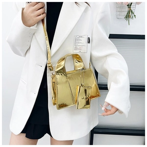Gros plan d'un sac à main doré effet miroir avec mini porte-monnaie et bandoulière chaîne