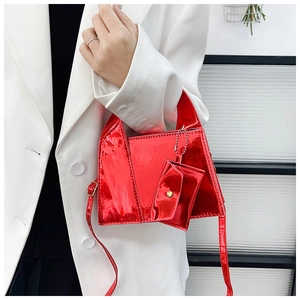 Détail du sac trapèze en cuir verni rouge avec mini porte-monnaie et boucle dorée chic